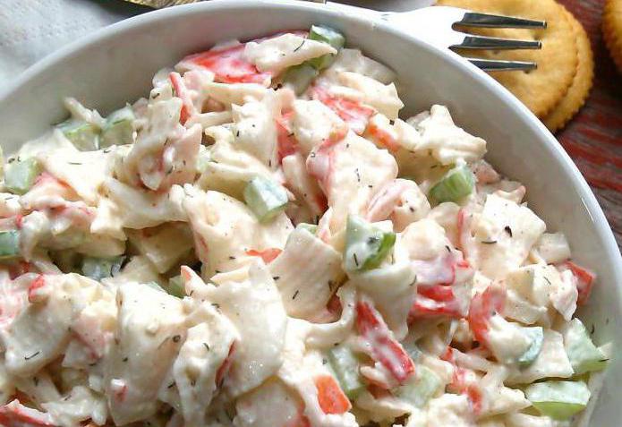 Salades simples avec des bâtonnets de crabe, des tomates et du fromage